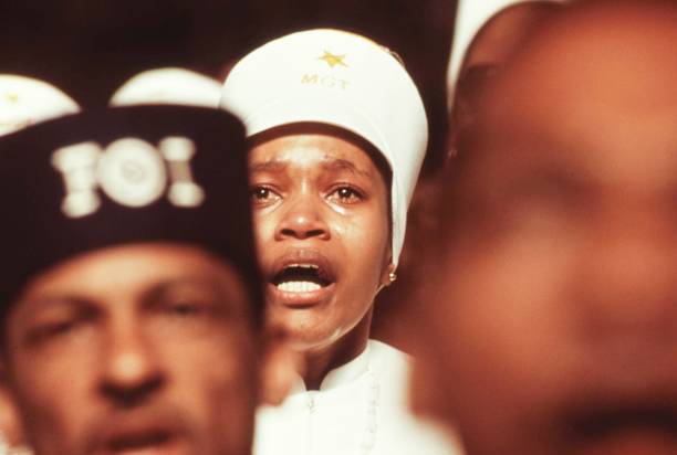A Black Muslim woman dressed in white garb is emotive during Elijah Muhammad's annual Savior's Day message in Chicago, Illinois, 1974. Image courtesy John White/US National Archives. (Photo via Smith Collection/Gado/Getty Images).